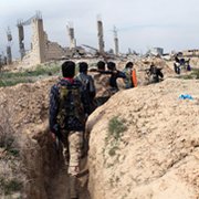 Syrian opposition fighters walk along a trench in the city of Deir Ezzor last week. Damascus on Tuesday asserted that rebels were plotting to conduct a chemical attack they would later blame on government forces.