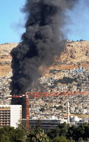 In a Syrian state media photo, black smoke pours from the site of a Wednesday bomb explosion in Damascus. The United States and allied nations estimate it could require tens of thousands of foreign troops to secure Syria's chemical- and suspected biological-weapon facilities (Syrian Arab News Agency).