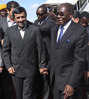 Zimbabwean President Robert Mugabe in 2010 welcomes then-Iranian President Mahmoud Ahmadinejad at Harare International Airport. A contested news report about a clandestine uranium trade understanding between Iran and Zimbabwe could revive debate over Tehran's ability to obtain uranium ore from other countries (AP Photo/Tsvangirayi Mukwazhi).