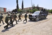 Syrian loyalist troops take position during fighting with rebels in the city of Aleppo last month. The United Kingdom and France say they have evidence that sarin nerve agent has been used in the Syrian civil war (AP Photo/Syrian Arab News Agency).
