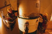 Workers inspect a Minuteman 3 intercontinental ballistic missile in 2002 at Malmstrom Air Force Base in Montana. The U.S. Air Force finished modifying its long-range nuclear missiles to each carry just one warhead.