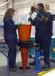 Workers handle a U.S. W-76 nuclear warhead. The federal atomic security agency would preserve ongoing efforts to monitor the nation’s fielded nuclear warheads if automatic funding cuts affect military programs in 2013, its leader said on Thursday (U.S. National Nuclear Security Administration photo).