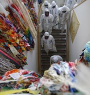 Technicians and journalists walk along a wall lined with paper cranes on Monday at Japan's Fukushima Daiichi nuclear power plant. More than a dozen nations revamped domestic atomic safety measures in response to damage sustained by the Japanese facility following an earthquake and tsunami three years ago, the U.S. Government Accountability Office said.