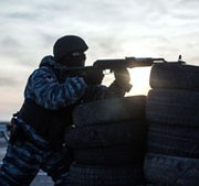 An armed pro-Russian serviceman stands guard at Chongar checkpoint blocking the entrance to Crimea on Monday. NATO has announced it will start conducting surveillance flights over Romania and Poland to better keep tabs on the security situation in nearby Ukraine, where Russian troops have intervened.