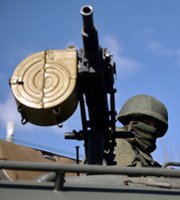 A man handles a Russian military vehicle's machine gun on Thursday at a checkpoint on Ukraine's Crimean Peninsula. Republican and Democratic U.S. senators said they do not expect an advancing Ukraine-aid bill to affect Russian cooperation on anti-WMD initiatives involving Iran and Syria.