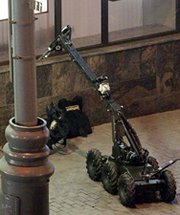 A robot lifts a rucksack containing a bomb shortly before it exploded in downtown Moscow, circa July 2003. Russia plans to field robots this year to guard its nuclear-armed missile sites.