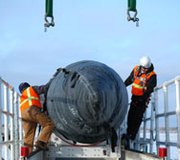 Technicians prepare a Ground Based Interceptor for emplacement into Missile Field 2 at Fort Greely, Alaska, in February 2012. A new audit criticizes the Pentagon for not providing sufficient information about its testing plan for the Ground-Based Midcourse Defense system.